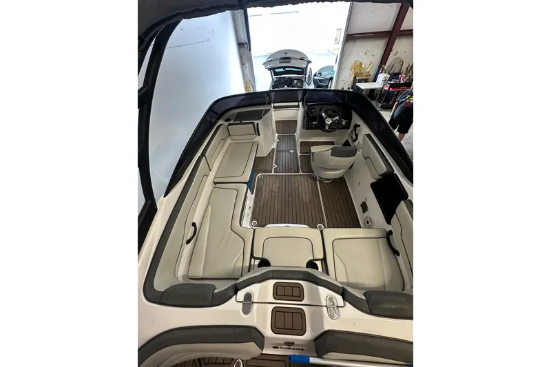Slide: The Image of 2020 Yamaha Boats AR190 interior with seating and steering wheel in a garage setting. - 10