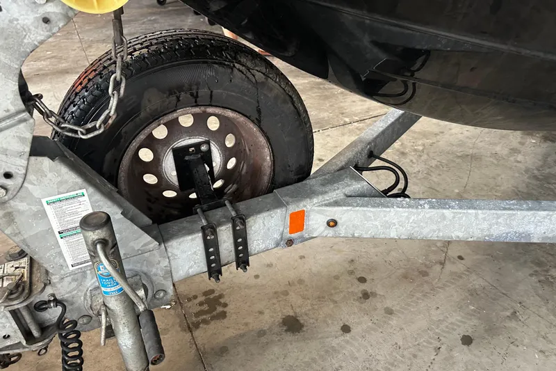 Slide: The Image of Trailer wheel and hitch of a 2020 Yamaha Boats AR190, parked indoors. - 2