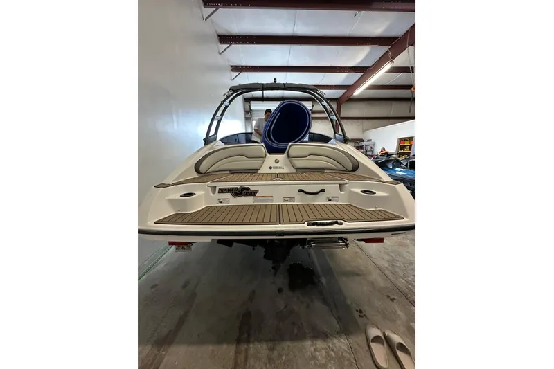 Slide: The Image of 2020 Yamaha Boats AR190 in a garage, rear view showing swim platform and seating. - 4