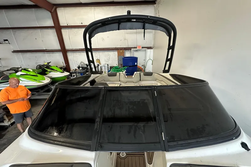 Slide: The Image of 2020 Yamaha Boats AR190 in a garage with jet skis and a person nearby. - 8