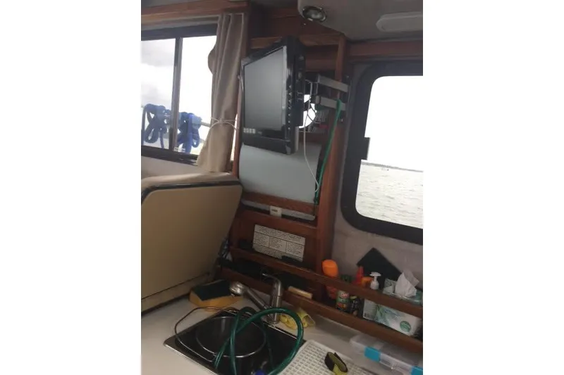 Slide: The Image of Interior of 2007 Ranger Tugs R-25 SC with mounted TV and kitchen essentials. - 30