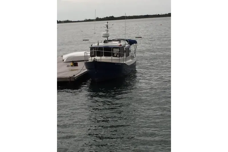 Slide: The Image of 2007 Ranger Tugs R-25 SC docked on calm water. - 2
