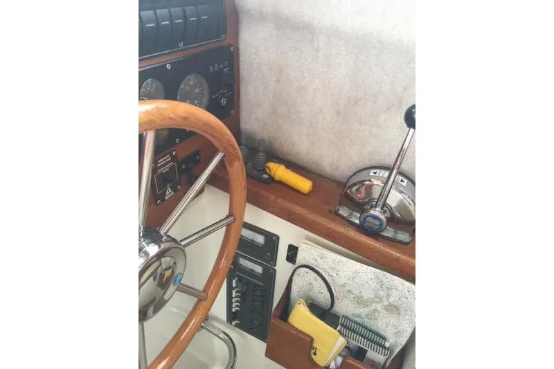 Slide: The Image of 2007 Ranger Tugs R-25 SC helm with wooden wheel, throttle, and navigation tools. - 24