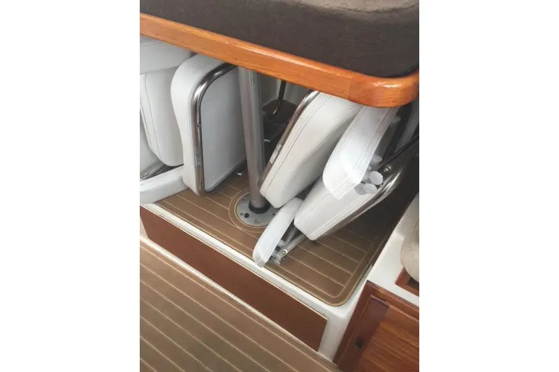 Slide: The Image of 2007 Ranger Tugs R-25 SC interior seating and storage area with wooden accents. - 33