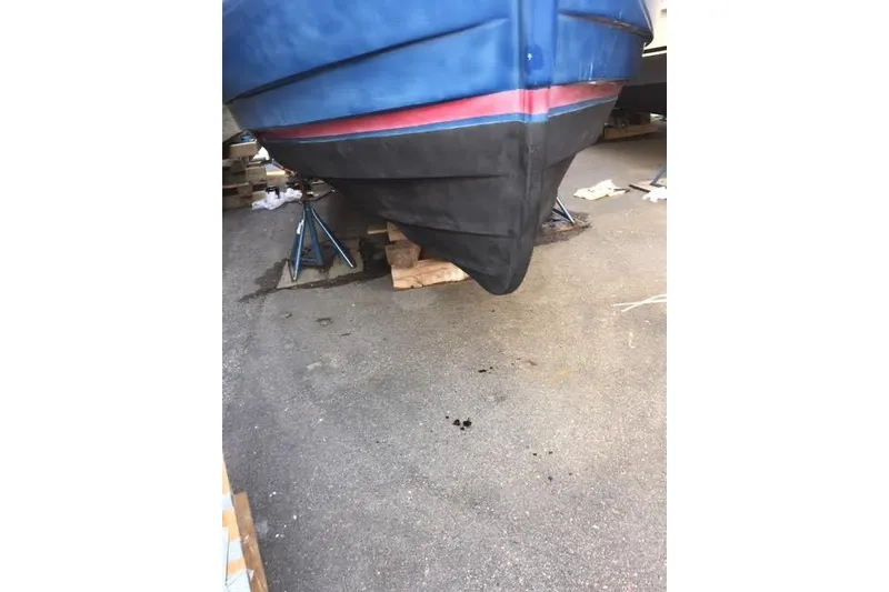 Slide: The Image of 2007 Ranger Tugs R-25 SC boat hull on stands, blue and red detailing. - 34