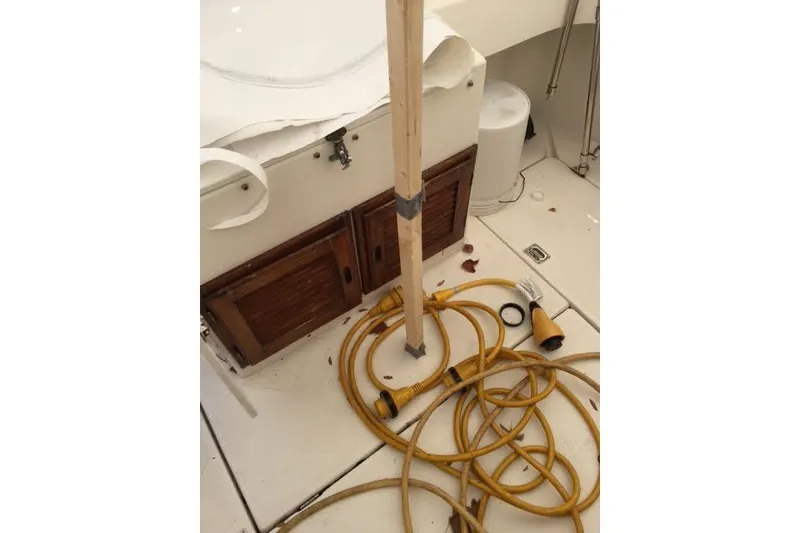 Slide: The Image of 2007 Ranger Tugs R-25 SC interior with coiled yellow hose and wooden cabinets. - 40