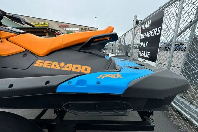 Slide: The Image of Sea-Doo SPARK TRIXX 2026 jet ski, orange and blue, in a parking lot. - 11