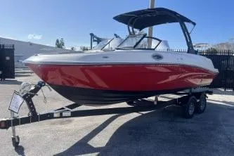 Slide: The Image of 2022 Bayliner VR6 Bowrider OB in red on trailer, parked outdoors. - 4