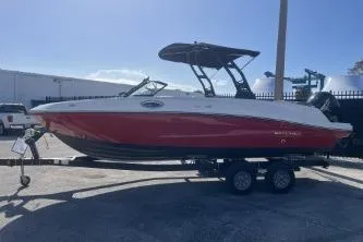 Slide: The Image of 2022 Bayliner VR6 Bowrider OB boat on trailer, red and white design, parked outdoors. - 5