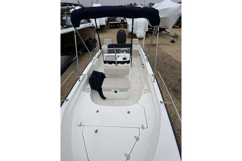 Slide: The Image of 2021 Boston Whaler 170 Montauk boat with seating and canopy, displayed outdoors. - 10