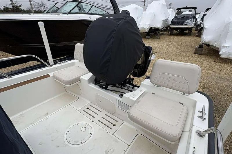 Slide: The Image of 2021 Boston Whaler 170 Montauk boat interior with cushioned seating and covered motor. - 11