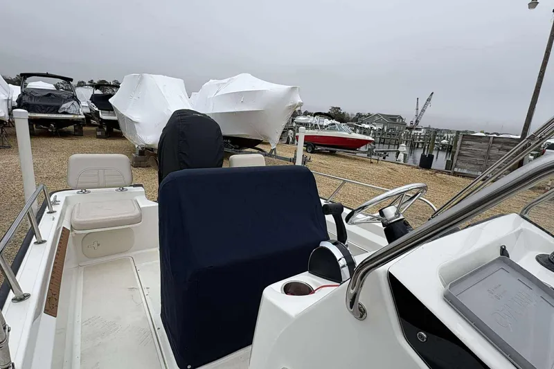 Slide: The Image of 2021 Boston Whaler 170 Montauk boat interior at a marina with covered boats. - 12