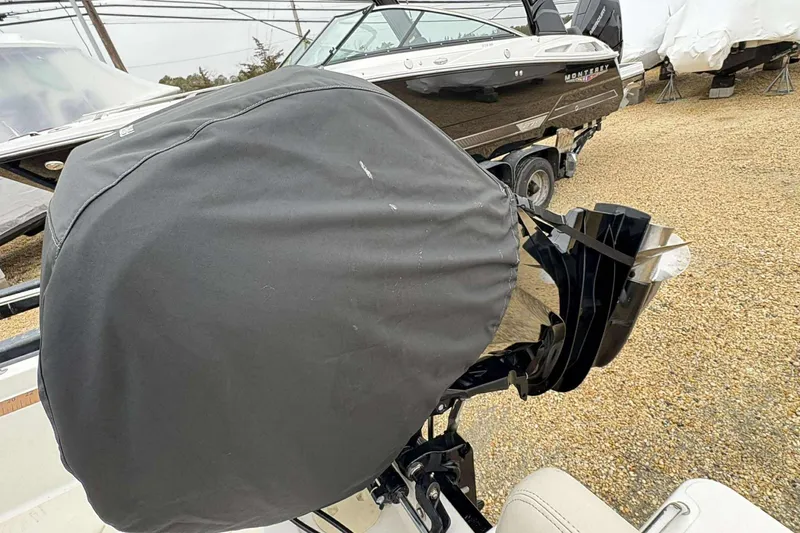 Slide: The Image of 2021 Boston Whaler 170 Montauk with covered outboard motor in a boatyard. - 13