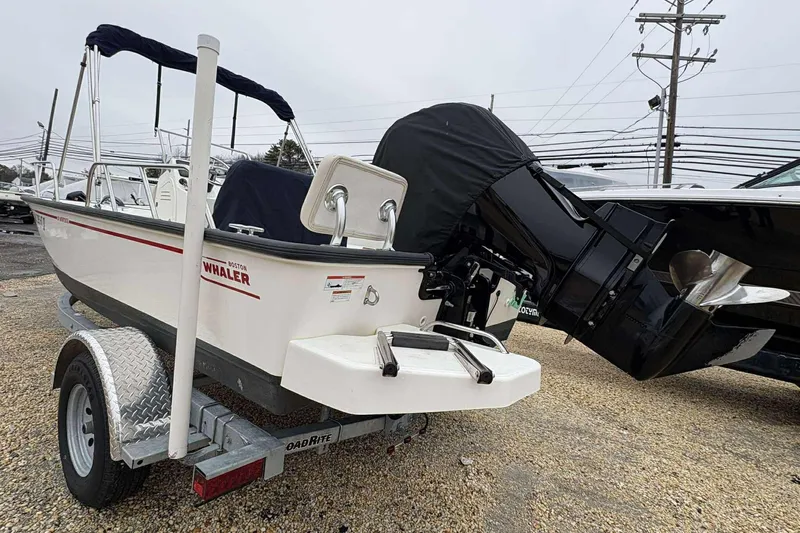 Slide: The Image of 2021 Boston Whaler 170 Montauk boat on trailer, rear view with outboard motor. - 14