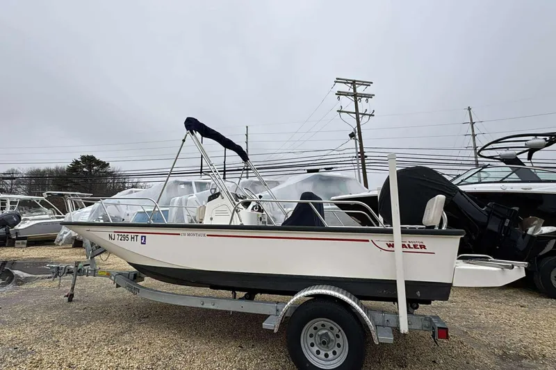 Slide: The Image of 2021 Boston Whaler 170 Montauk boat on trailer, parked outdoors. - 2