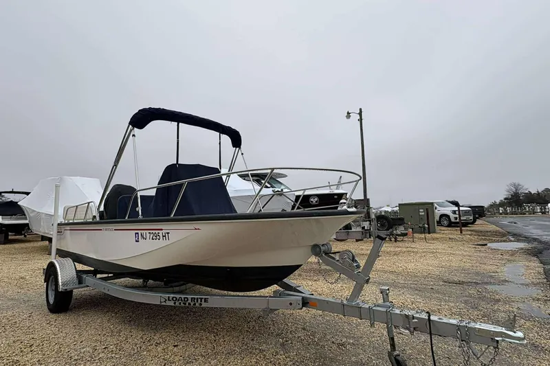 Slide: The Image of 2021 Boston Whaler 170 Montauk boat on trailer, parked outdoors on a cloudy day. - 4