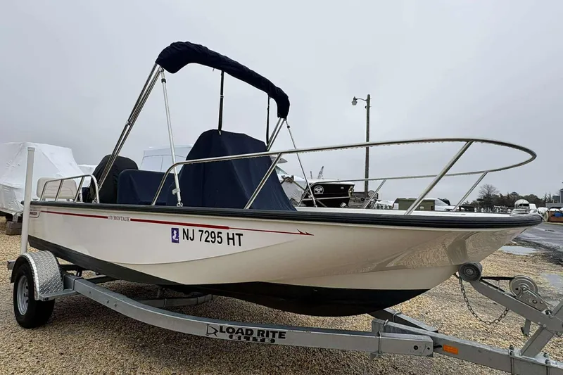 Slide: The Image of 2021 Boston Whaler 170 Montauk boat on trailer, parked outdoors on a cloudy day. - 5