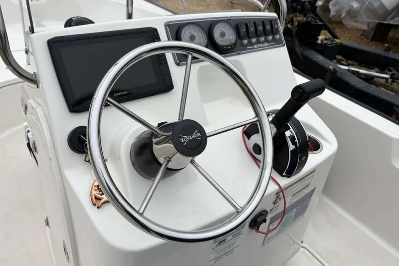 Slide: The Image of 2021 Boston Whaler 170 Montauk boat console with steering wheel and controls. - 9