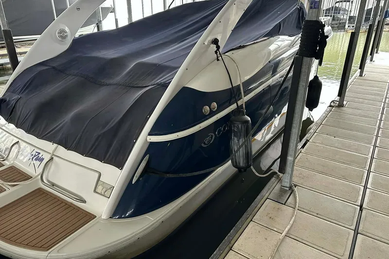 Slide: The Image of 2004 Cobalt 360 Cruiser docked, covered with a navy tarp, in a marina setting. - 10