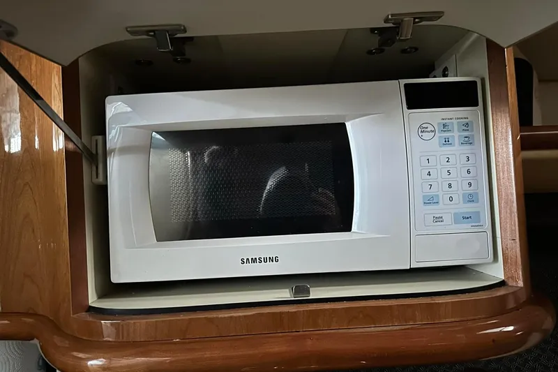 Slide: The Image of White Samsung microwave in a 2004 Cobalt 360 Cruiser's wooden cabinet. - 12
