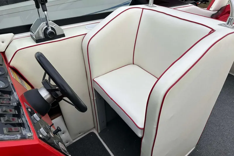 Slide: The Image of 1987 IMP 255 Eleganza boat interior with white and red-trimmed seating and steering wheel. - 15