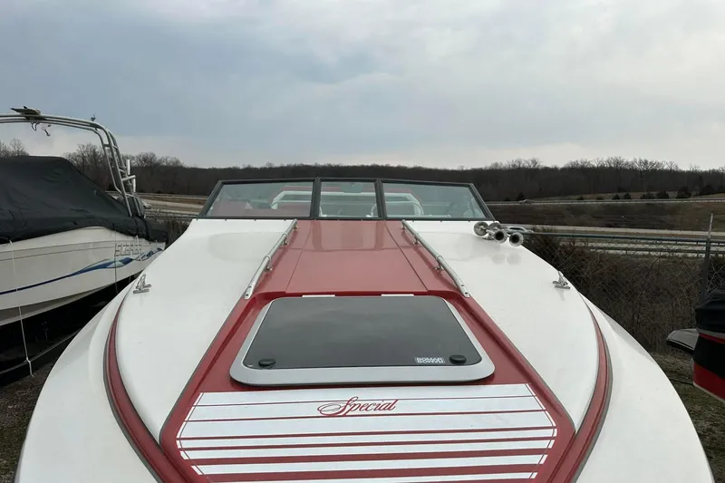 Slide: The Image of 1987 IMP 255 Eleganza boat with red and white detailing, parked outdoors. - 18