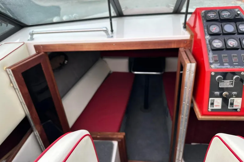 Slide: The Image of 1987 IMP 255 Eleganza boat interior with red dashboard and cozy cabin seating. - 3