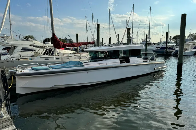 The Image of 2023 Axopar 37 XC Cross Cabin boat docked in a marina with other vessels. - 0