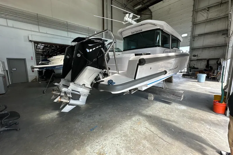 Slide: The Image of 2023 Axopar 37 XC Cross Cabin in a workshop, showcasing dual outboard motors. - 12