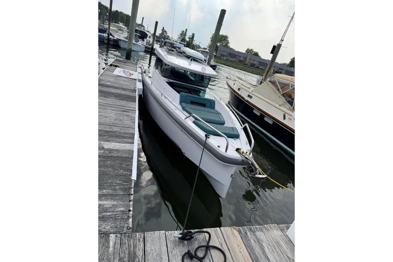Slide: The Image of 2023 Axopar 37 XC Cross Cabin docked at a marina, showcasing sleek design. - 13