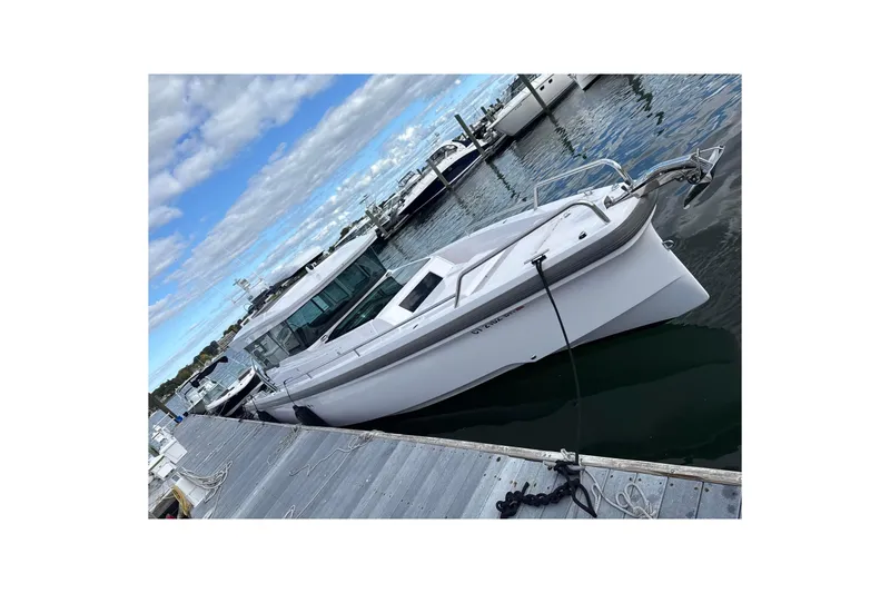 Slide: The Image of 2023 Axopar 37 XC Cross Cabin boat docked at marina under cloudy sky. - 14