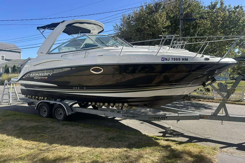 Slide: The Image of 2019 Monterey 295 Sport Yacht on trailer, parked outdoors, side view. - 2