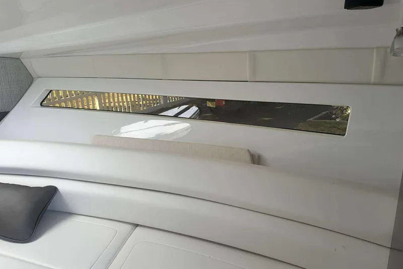 Slide: The Image of Interior of 2019 Monterey 295 Sport Yacht with sleek white seating and window. - 20