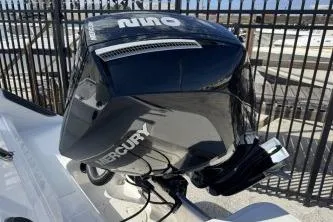 Slide: The Image of 2023 Trophy T24 CC boat with Mercury outboard engine, docked near a fence. - 11