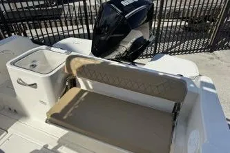 Slide: The Image of 2023 Trophy T24 CC boat interior with seating and motor, parked outdoors. - 5