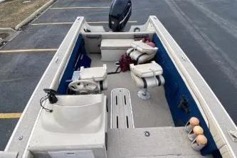 Slide: The Image of 1999 Sylvan 1700 boat interior with seating and steering wheel, parked in a lot. - 3