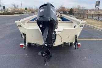 Slide: The Image of 1999 Sylvan 1700 boat with 90 HP outboard motor, parked in a lot. - 5