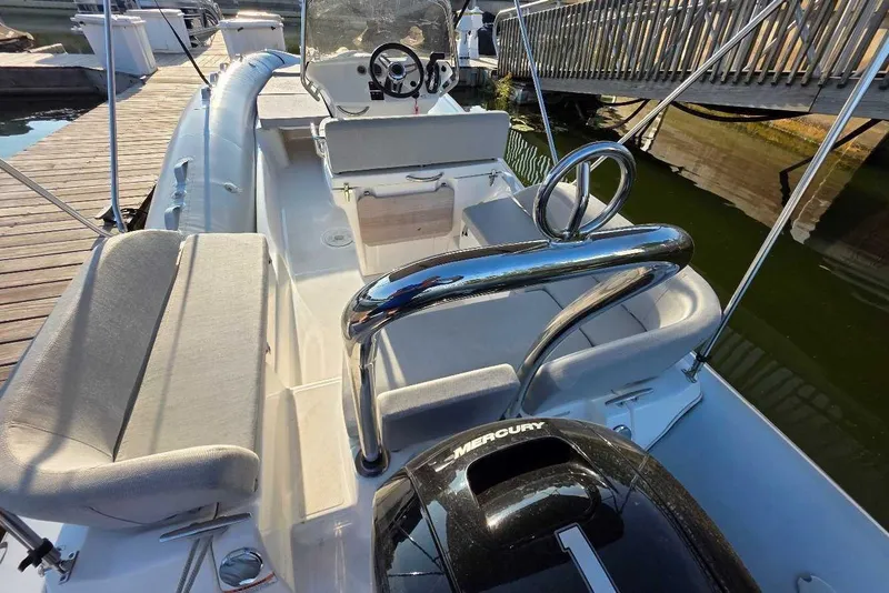 Slide: The Image of 2024 Zodiac N-ZO 680 boat interior with seating and Mercury engine at dock. - 3