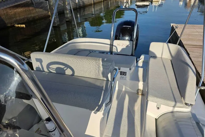 Slide: The Image of 2024 Zodiac N-ZO 680 boat interior with seating and steering wheel, docked at marina. - 7
