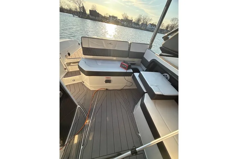 Slide: The Image of 2023 Monterey 298SS Super Sport boat interior with cushioned seating by the water. - 9