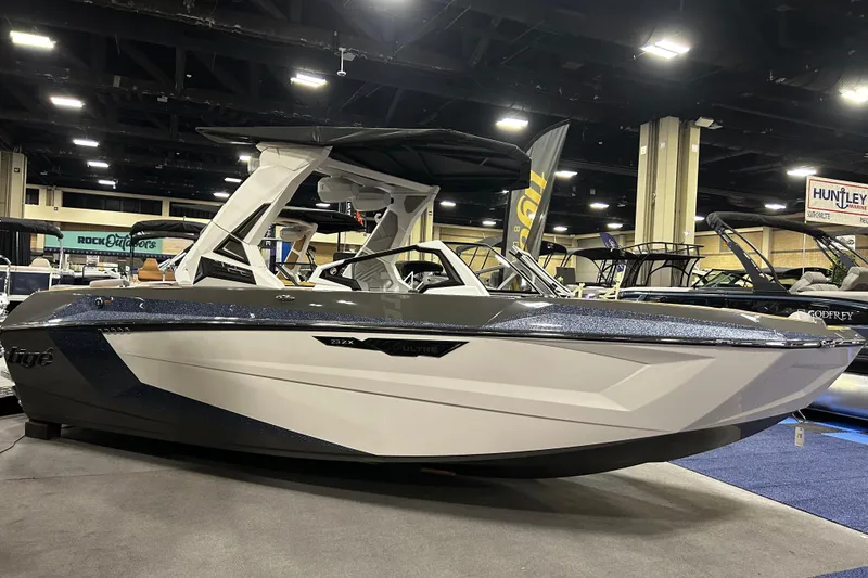 Slide: The Image of 2026 Tigé Ultré 23ZX boat displayed at an indoor boat show. - 13