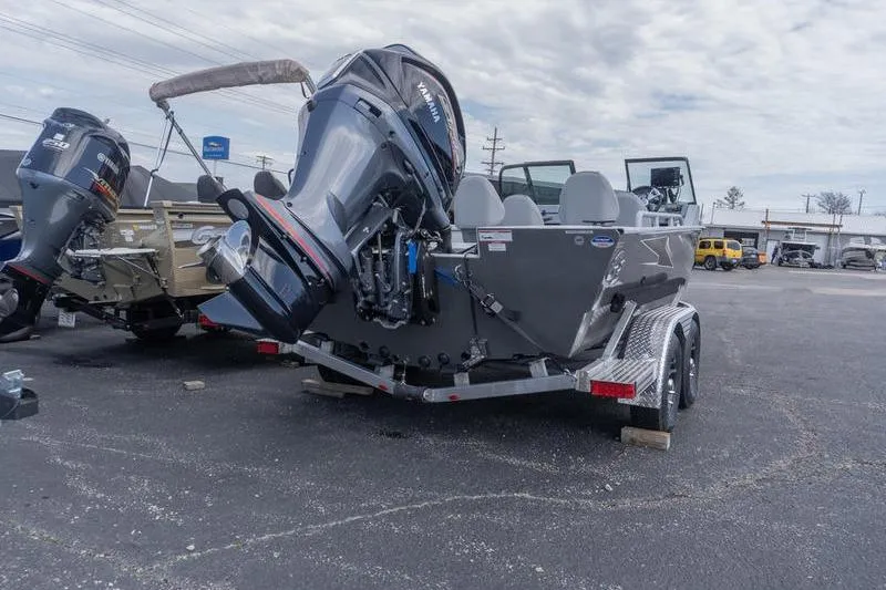 Slide: The Image of 2026 G3 Sportsman 2400 boat on trailer, featuring powerful outboard motor, parked outdoors. - 6