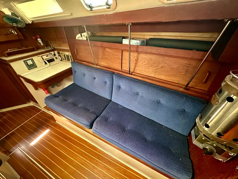Slide: The Image of Interior of a 1987 Catalina 34 yacht with blue couch and wood finish. - 14
