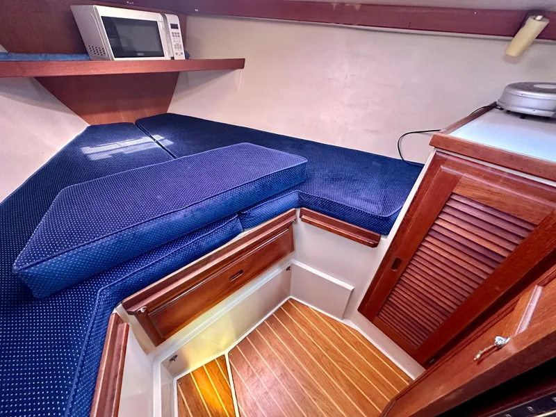 Slide: The Image of Interior of a 1987 Catalina 34 yacht with blue cushions. - 16
