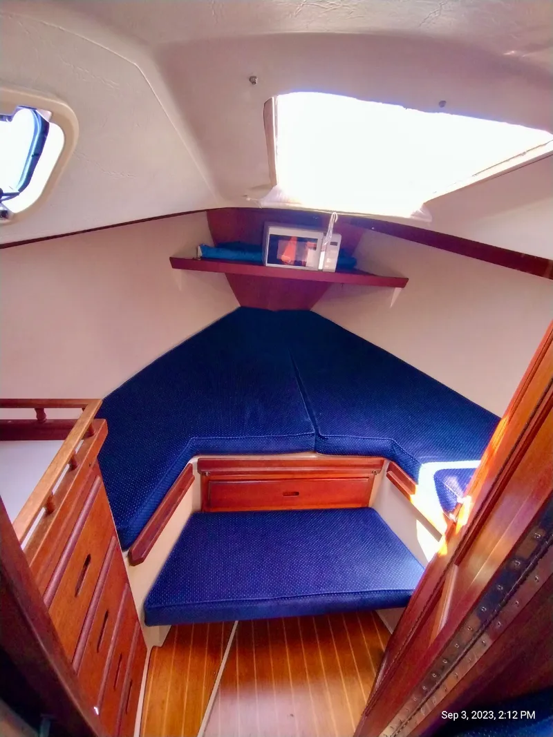 Slide: The Image of Interior of a 1987 Catalina 34 yacht with blue cushions. - 17