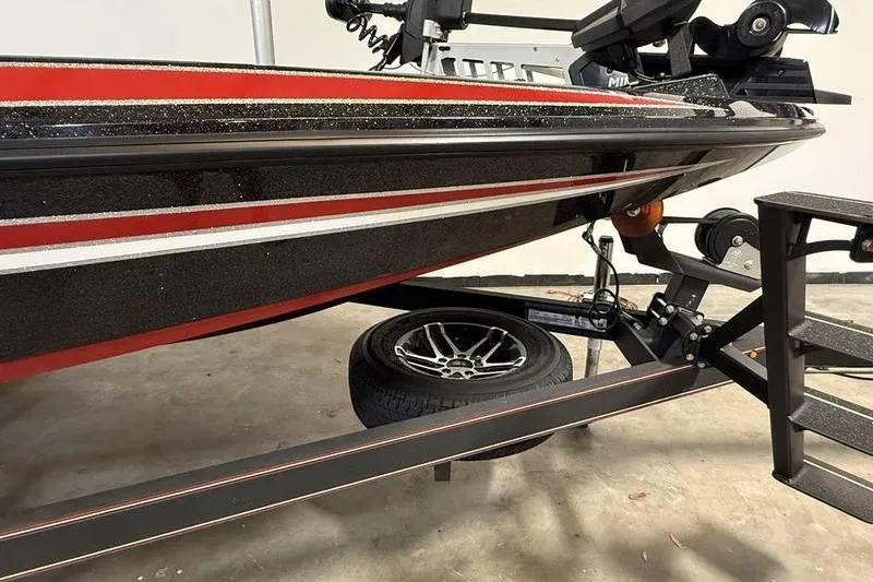 Slide: The Image of 2022 Skeeter ZX150 boat on trailer, featuring sleek red and black design. - 2