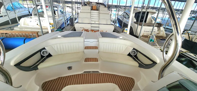 Slide: The Image of 2007 Cobalt 343 boat interior with white seating and wood accents in a marina. - 13