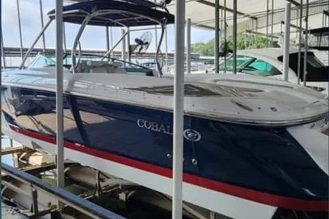 Slide: The Image of 2007 Cobalt 343 boat docked in a marina, featuring sleek design and blue exterior. - 38