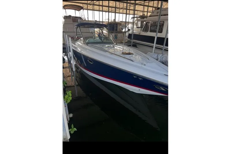 Slide: The Image of 2007 Cobalt 343 boat docked in a marina, featuring a sleek blue and white design. - 39