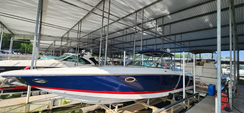 Slide: The Image of 2007 Cobalt 343 boat in marina, blue hull with red stripe, under covered dock. - 4